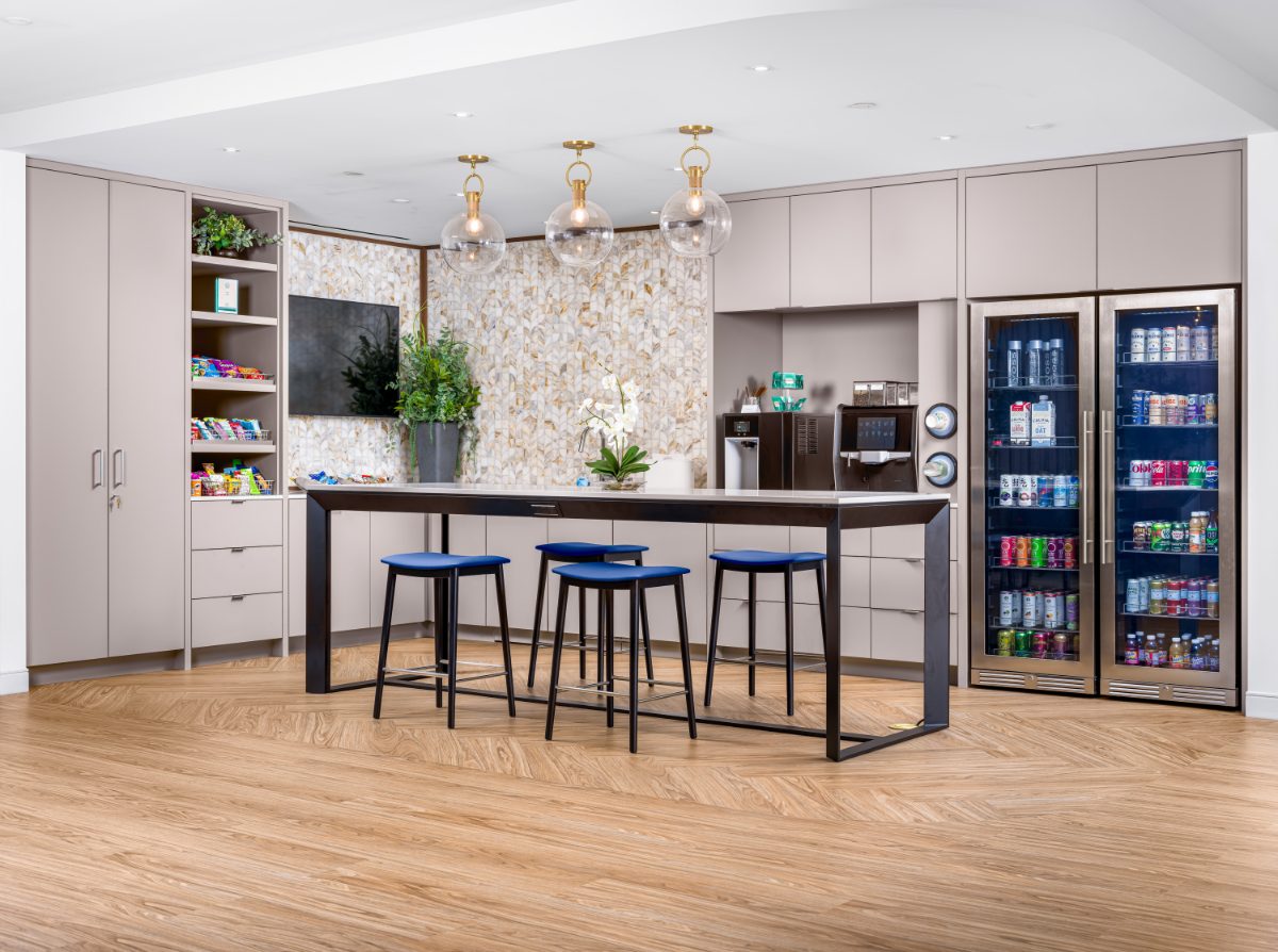 JAMS Cafe at JAMS Los Angeles — black-frame island, three globe pendants, marble mosaic wall, espresso bar, and two glass-door beverage fridges.