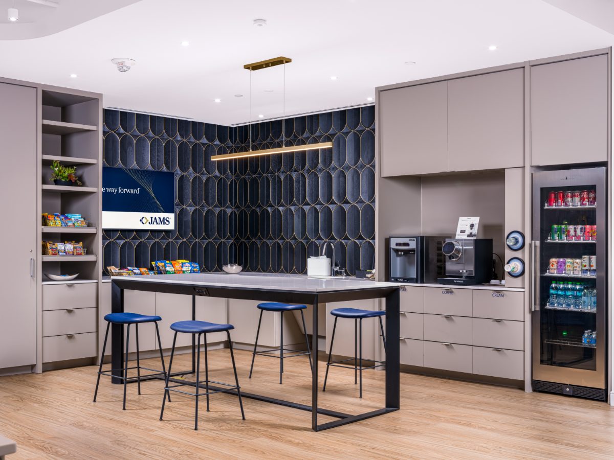 JAMS Cafe at JAMS Atlanta, Promenade Tower — counter island with navy stools, brass linear pendant, navy arched-pattern wallpaper, beverage cooler.