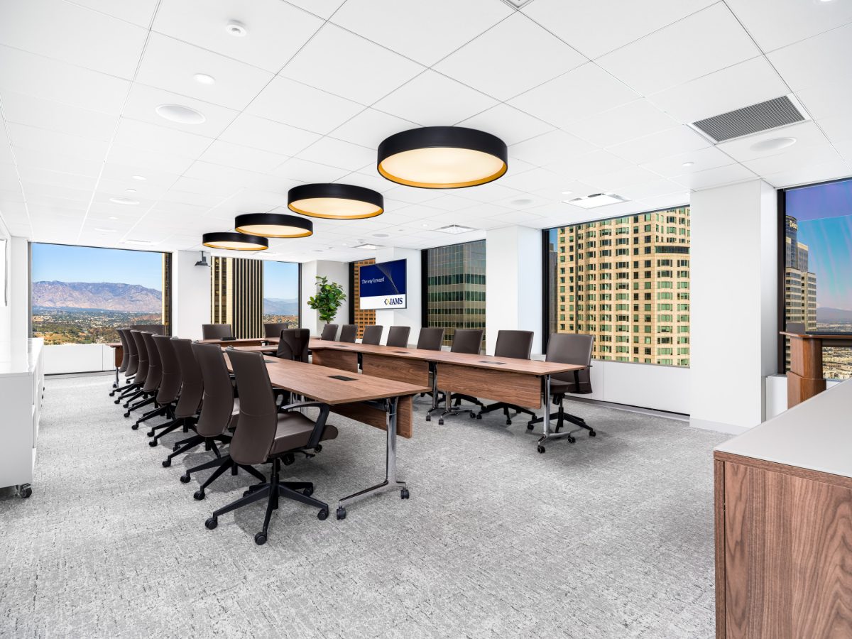 JAMS Los Angeles Boardroom 12 — U-shaped walnut table, charcoal leather chairs, drum pendants, San Gabriel and downtown LA skyline through two walls of glass.