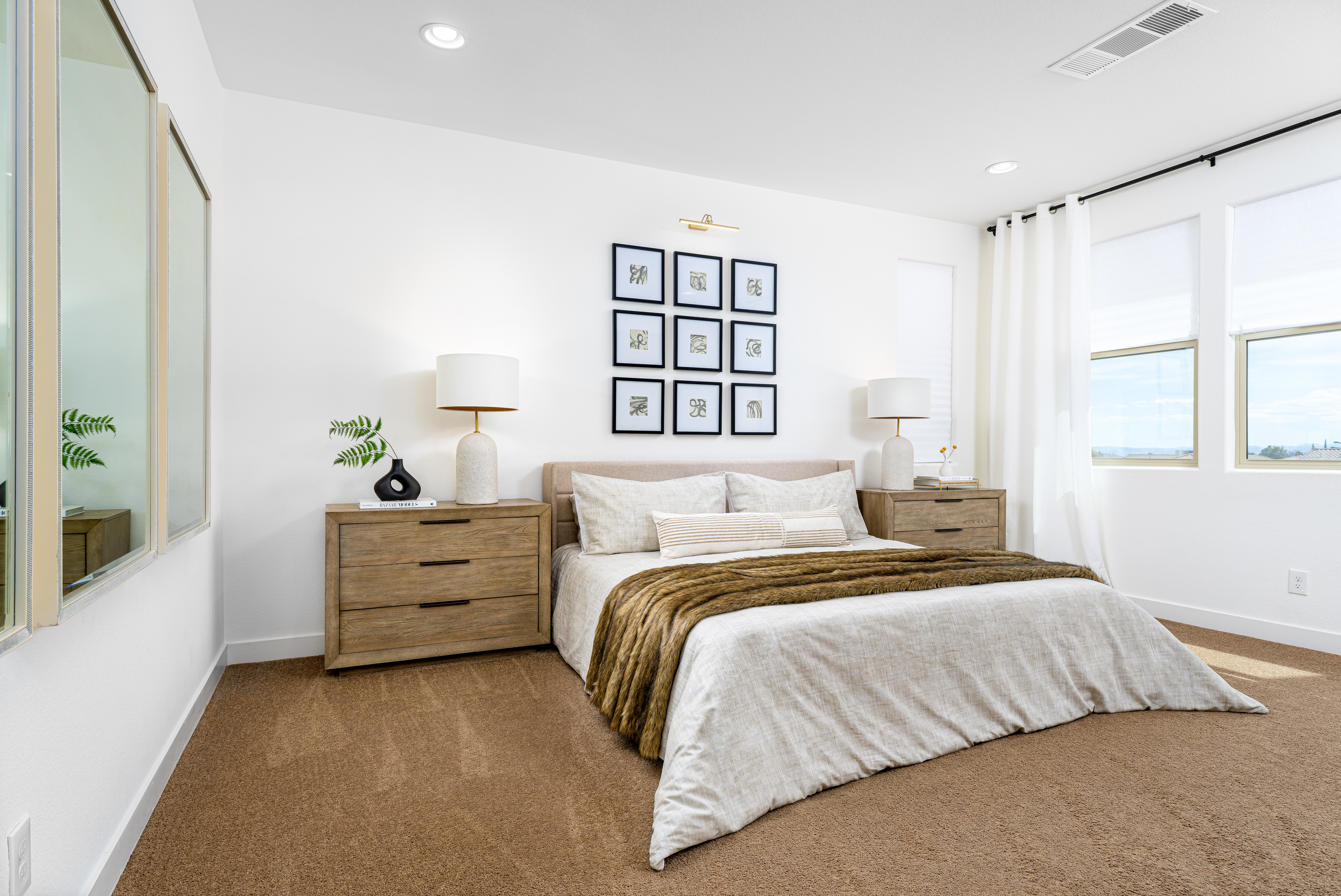 Bedroom at a Stately contemporary minimalist home in Las Vegas (11531 SSS) — oak panel bed, oak nightstand pair, 9-frame abstract gallery wall, brass picture light.