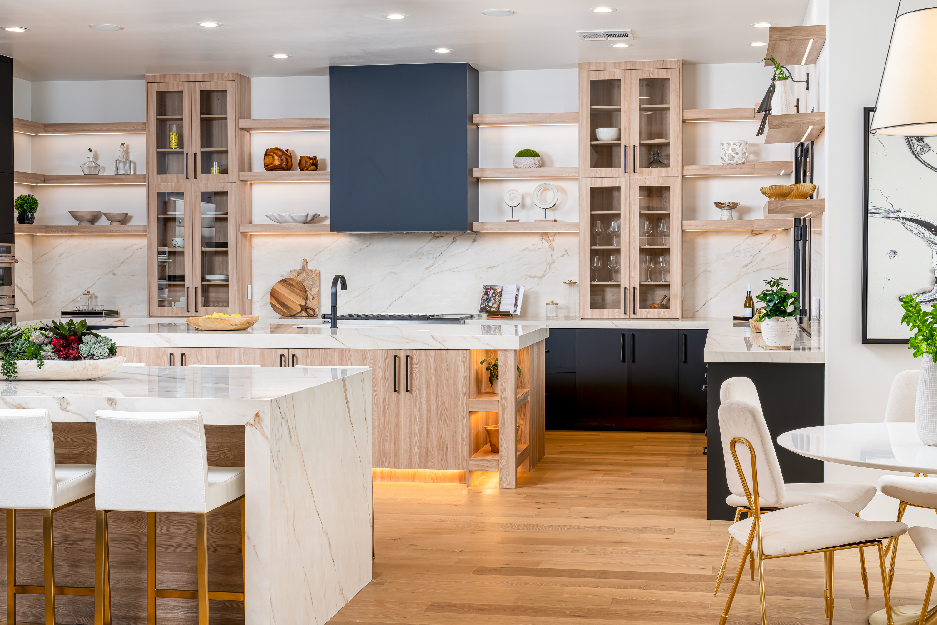 Kitchen at a Stately modern transitional luxury home in Las Vegas (1533 TS) — white-and-wood coffered ceiling, marble fireplace, grey sectional, corduroy stools.
