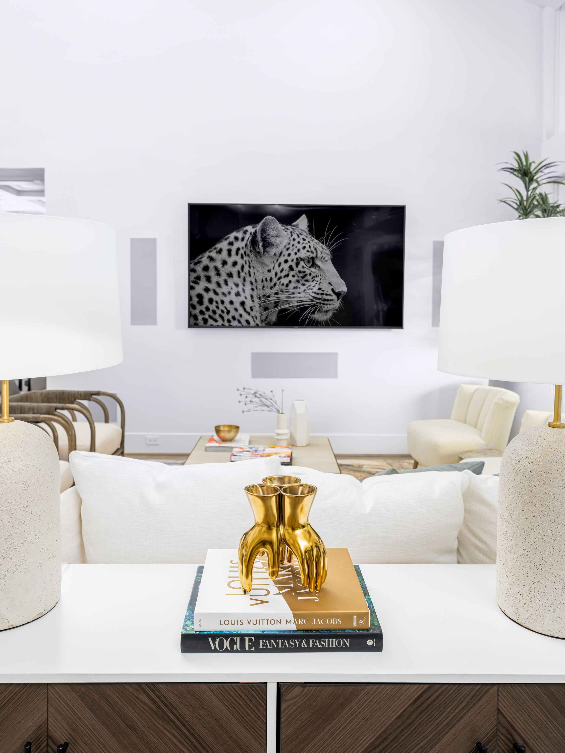 Living Room at a Stately open contemporary home in Las Vegas (2327 AD) — vaulted ceiling, central fireplace, faceted metallic coffee table, blue accent art.