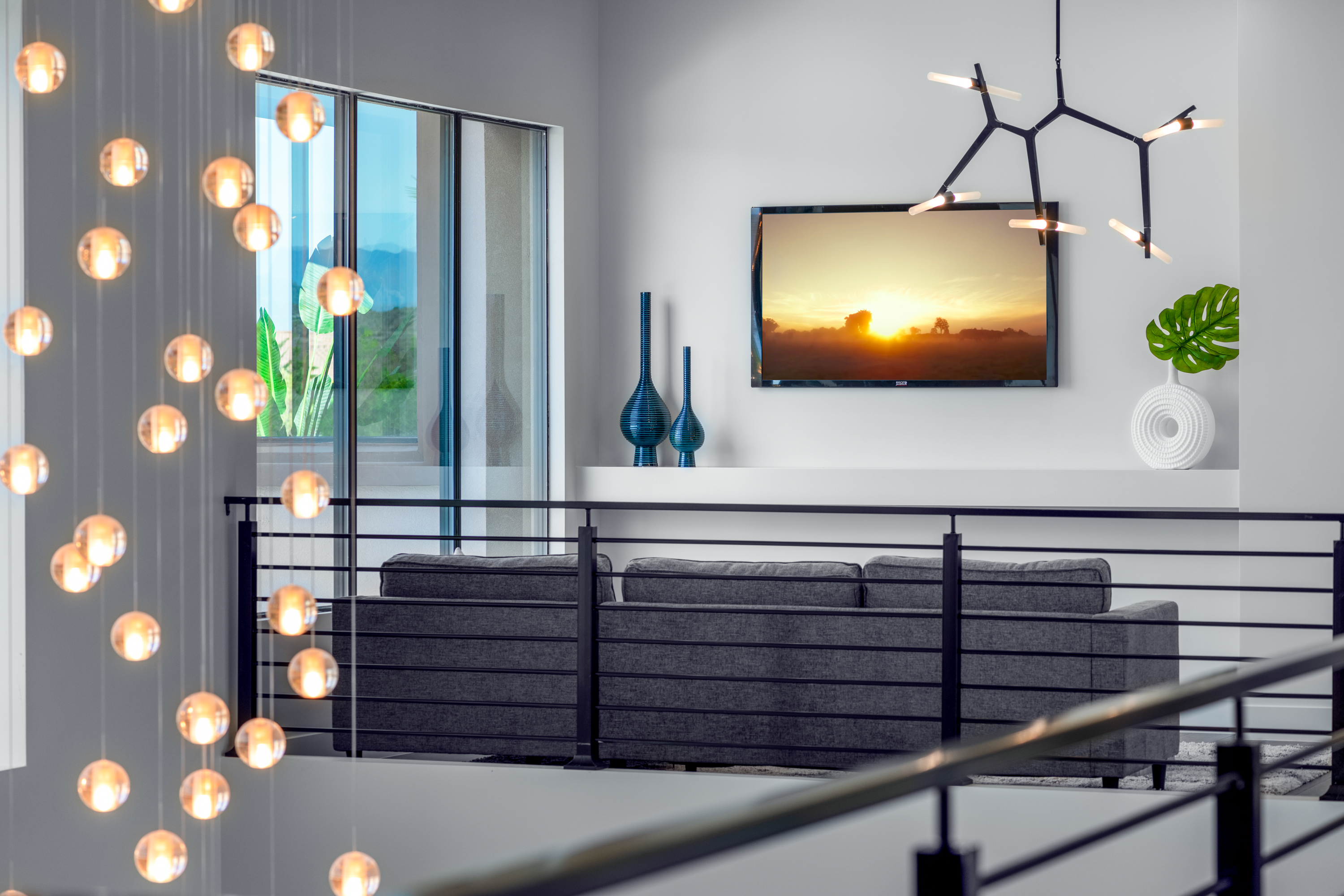 Loft at a Stately modern desert resort home in Las Vegas (38 RA) — marble fireplace surround, walnut accent stool, abstract art, palm view.