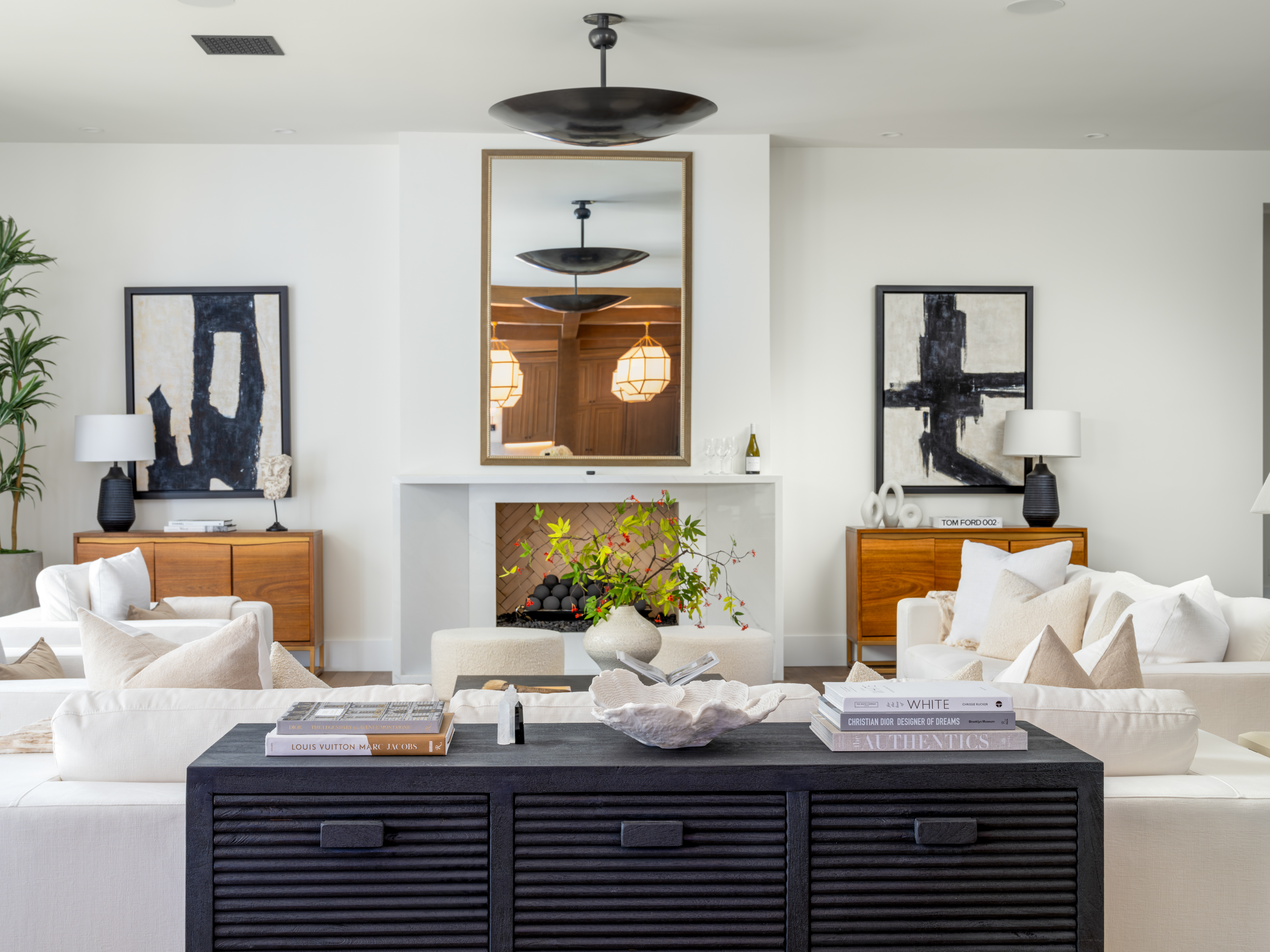 Living Room at a Stately Mediterranean revival home in Las Vegas (8833 GL) — exposed wood ceiling beams, brass pendant lanterns, cream sofas, dark coffee tables.