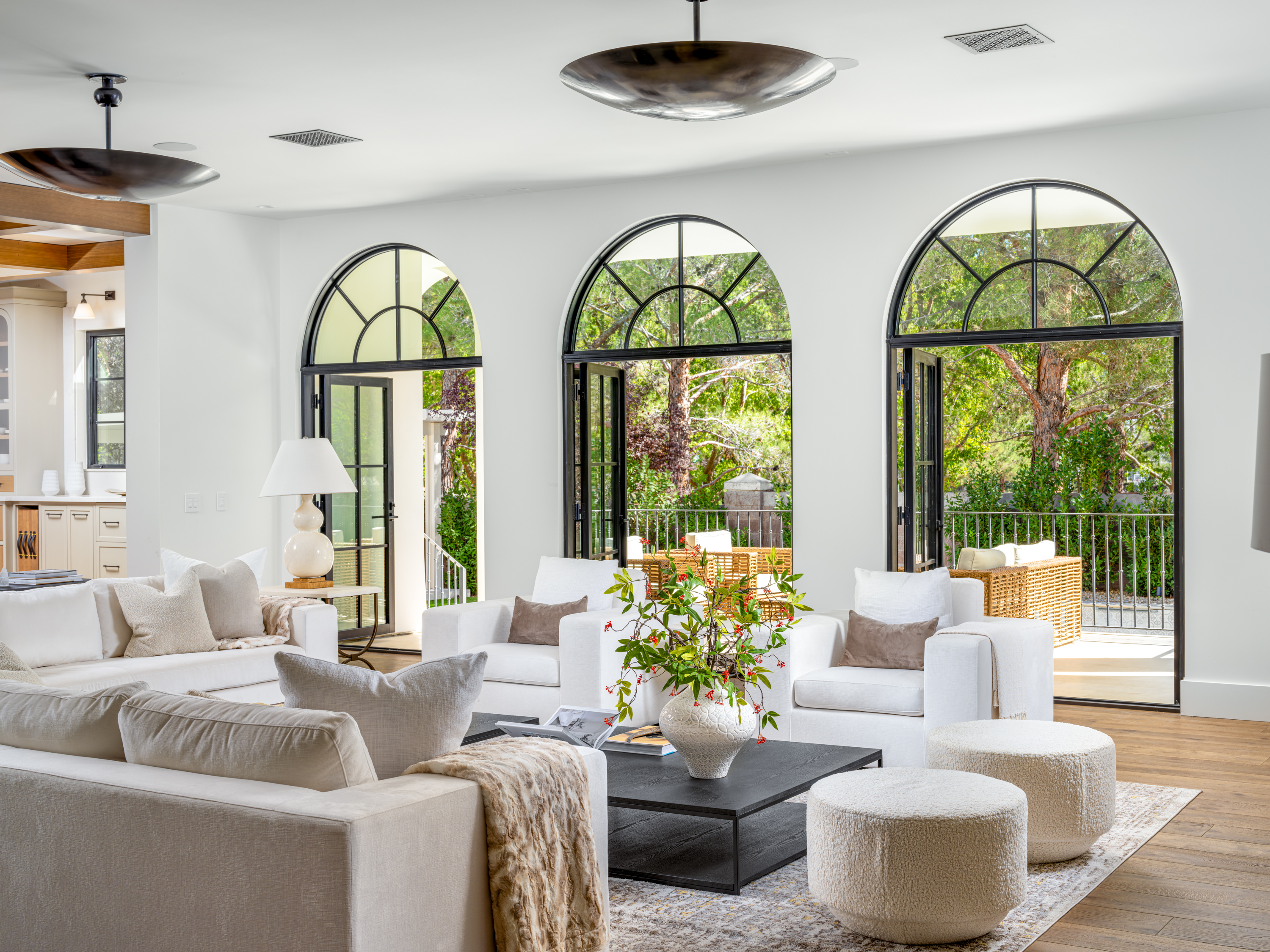 Living Room at a Stately Mediterranean revival home in Las Vegas (8833 GL) — exposed wood ceiling beams, brass pendant lanterns, cream sofas, dark coffee tables.