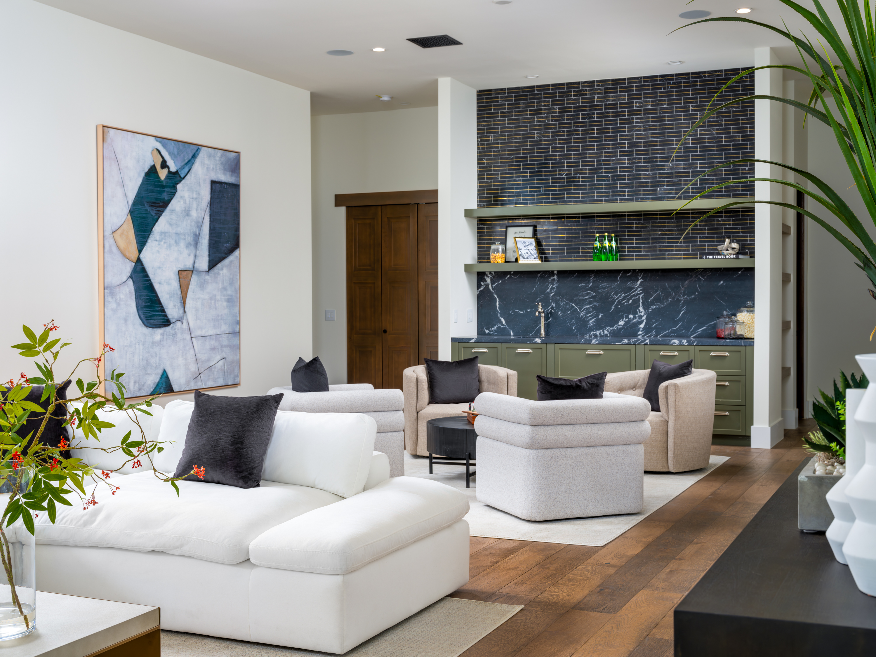 Living Room at a Stately Mediterranean revival home in Las Vegas (8833 GL) — exposed wood ceiling beams, brass pendant lanterns, cream sofas, dark coffee tables.