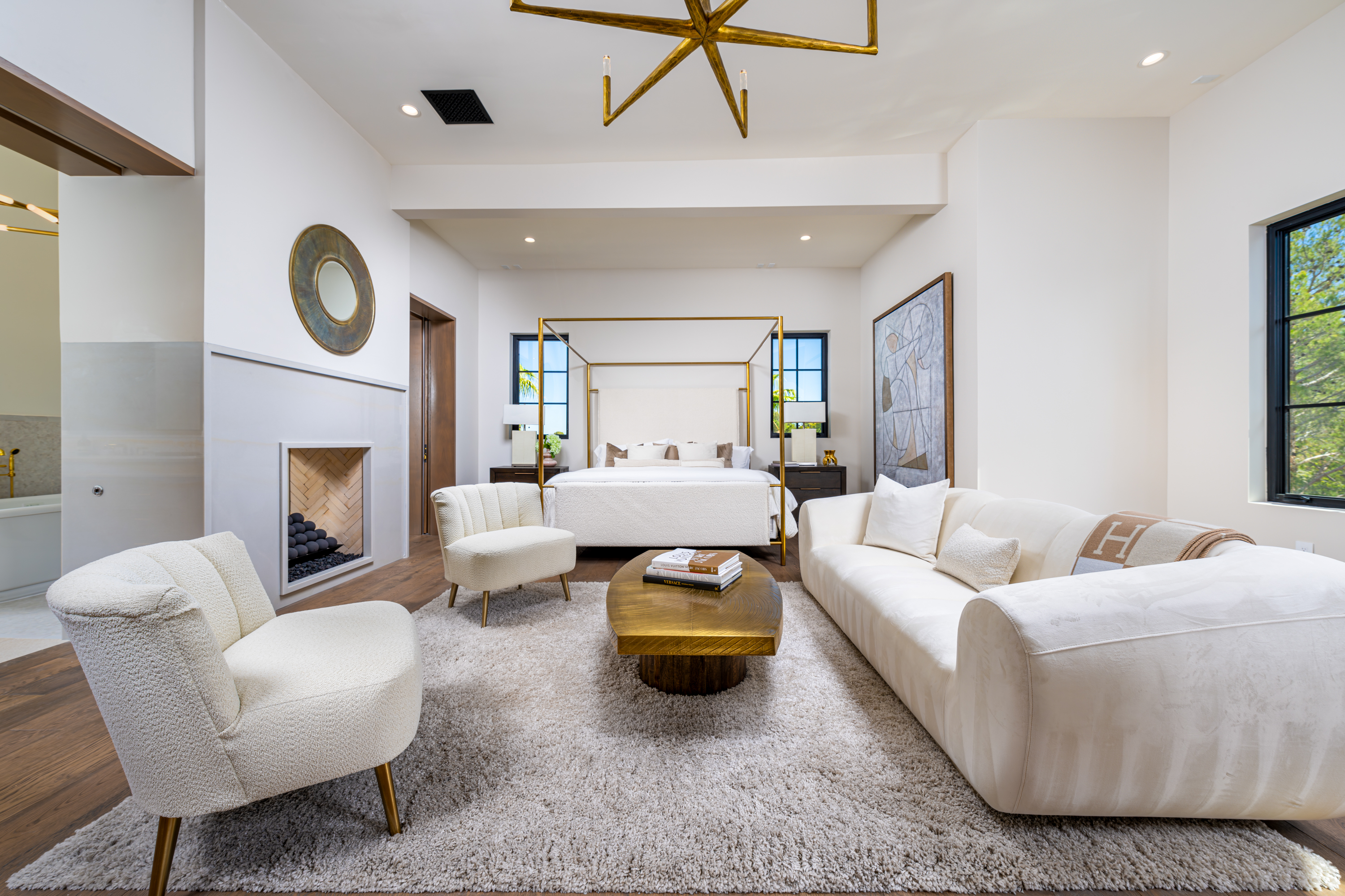 Master Bedroom at a Stately Mediterranean revival home in Las Vegas (8833 GL) — exposed wood ceiling beams, brass pendant lanterns, cream sofas, dark coffee tables.