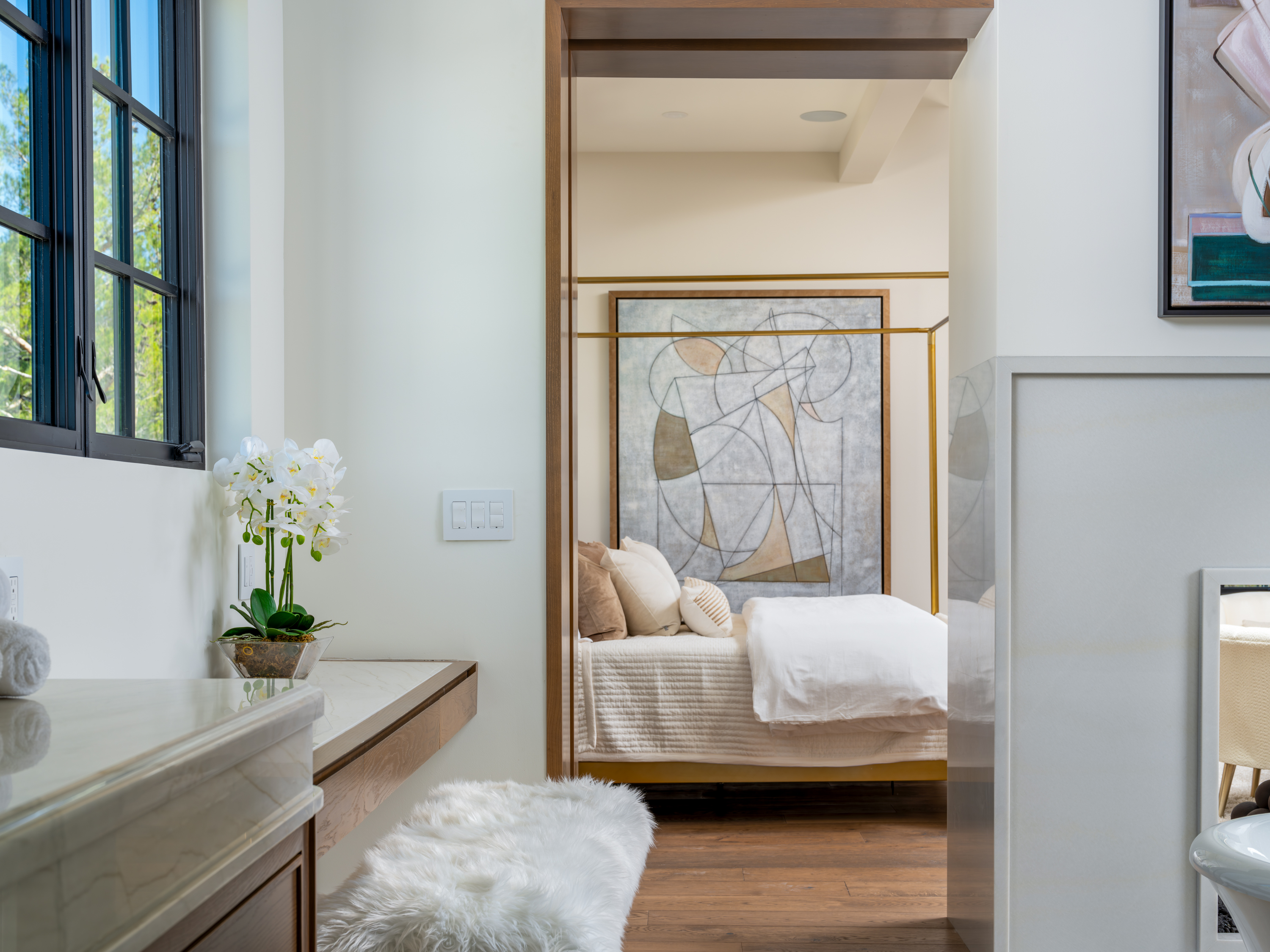 Master Bedroom at a Stately Mediterranean revival home in Las Vegas (8833 GL) — exposed wood ceiling beams, brass pendant lanterns, cream sofas, dark coffee tables.