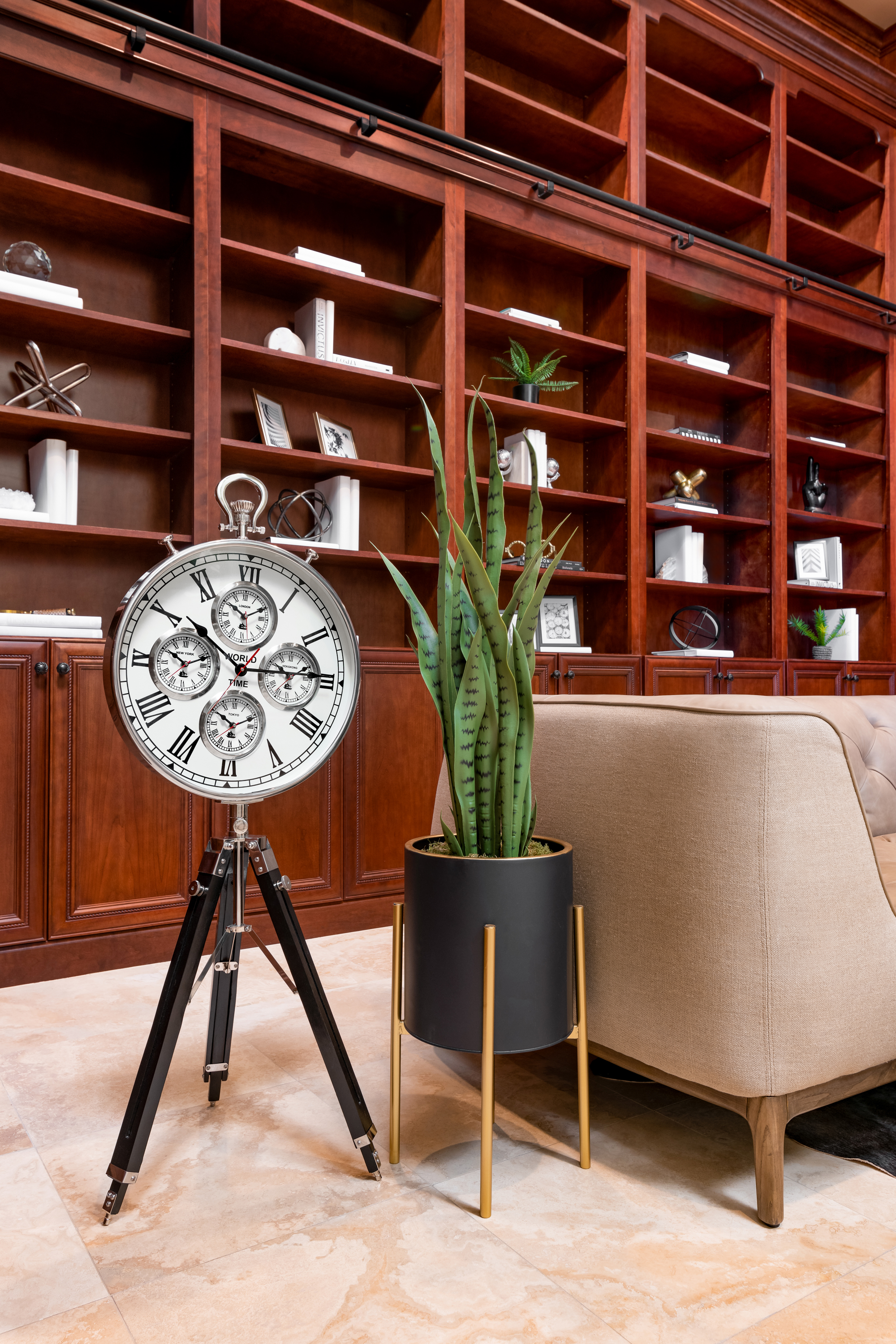 Library at a Stately traditional gentleman's library home in Las Vegas (2297 FA) — cherry bookcases, rolling library ladder, tufted cream sofa, antique tripod clock.