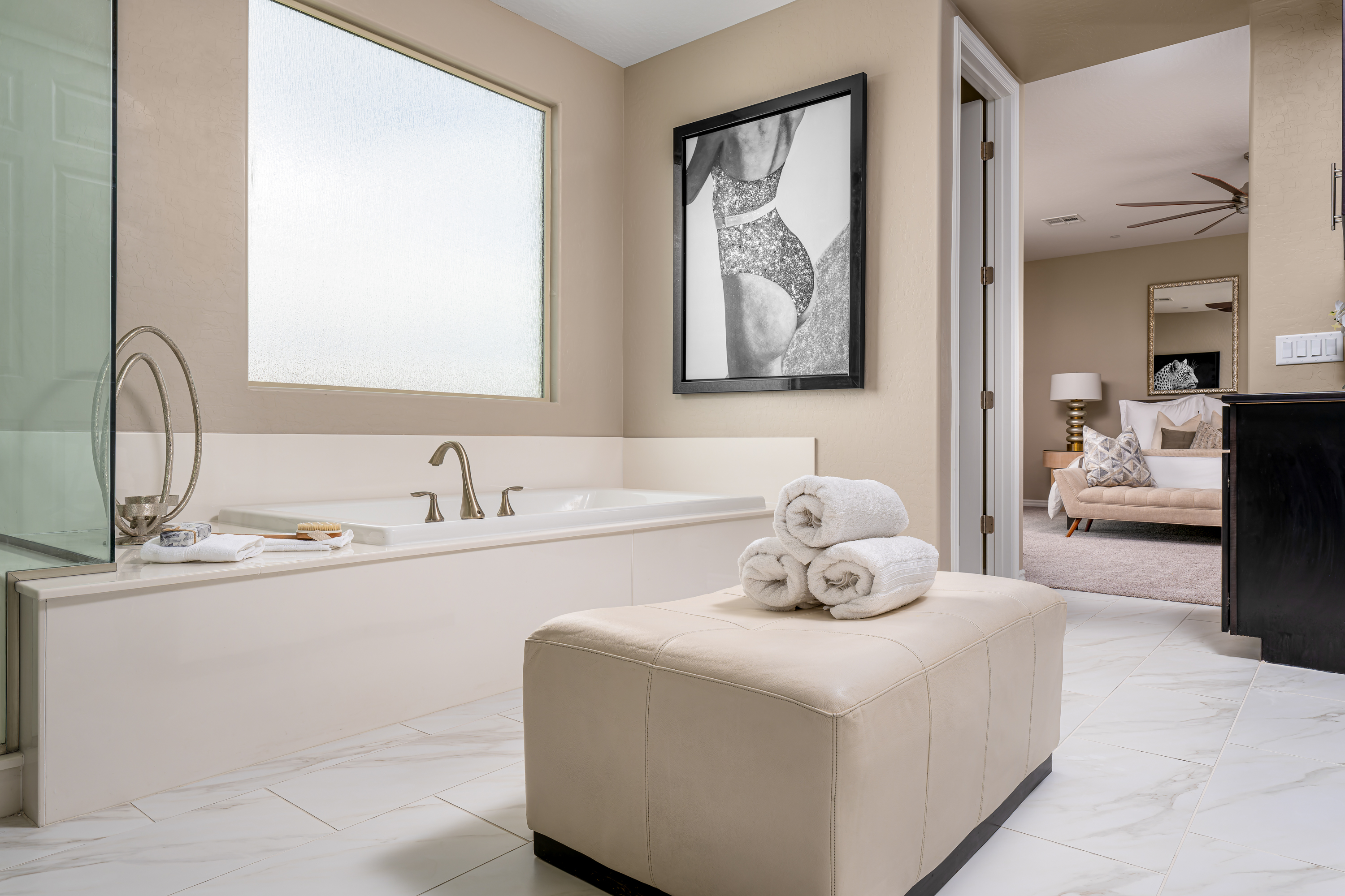 Master Bathroom at a Stately contemporary Moroccan-influenced home in Las Vegas (2818 PSA) — navy velvet chairs, geometric blue-white art, gold accents, marble tile.