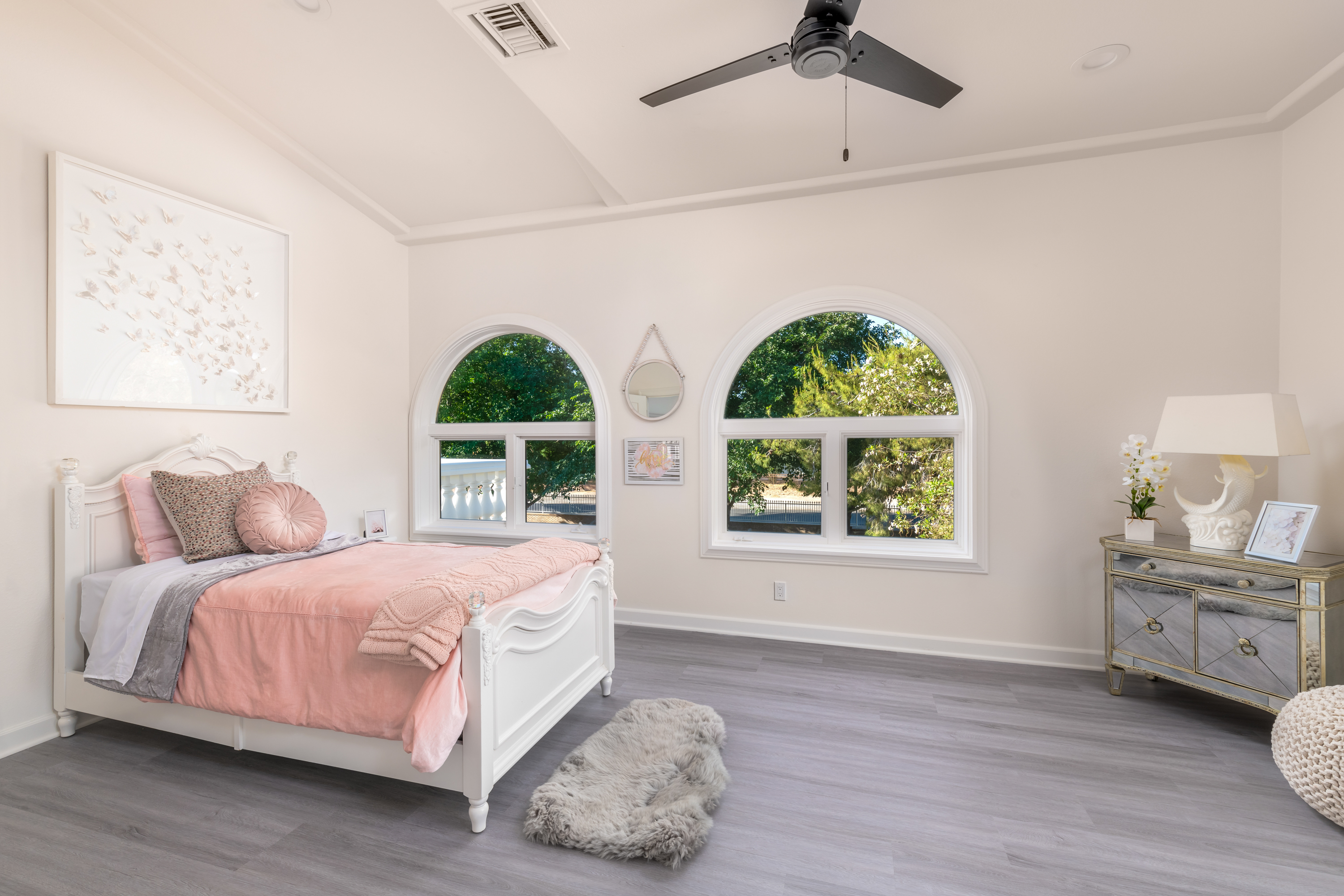 Bedroom at a Stately modern luxury fireplace centerpiece home in Las Vegas (3540 ETL) — herringbone tile fireplace, reclaimed wood drum table, bouclé chairs, arched windo