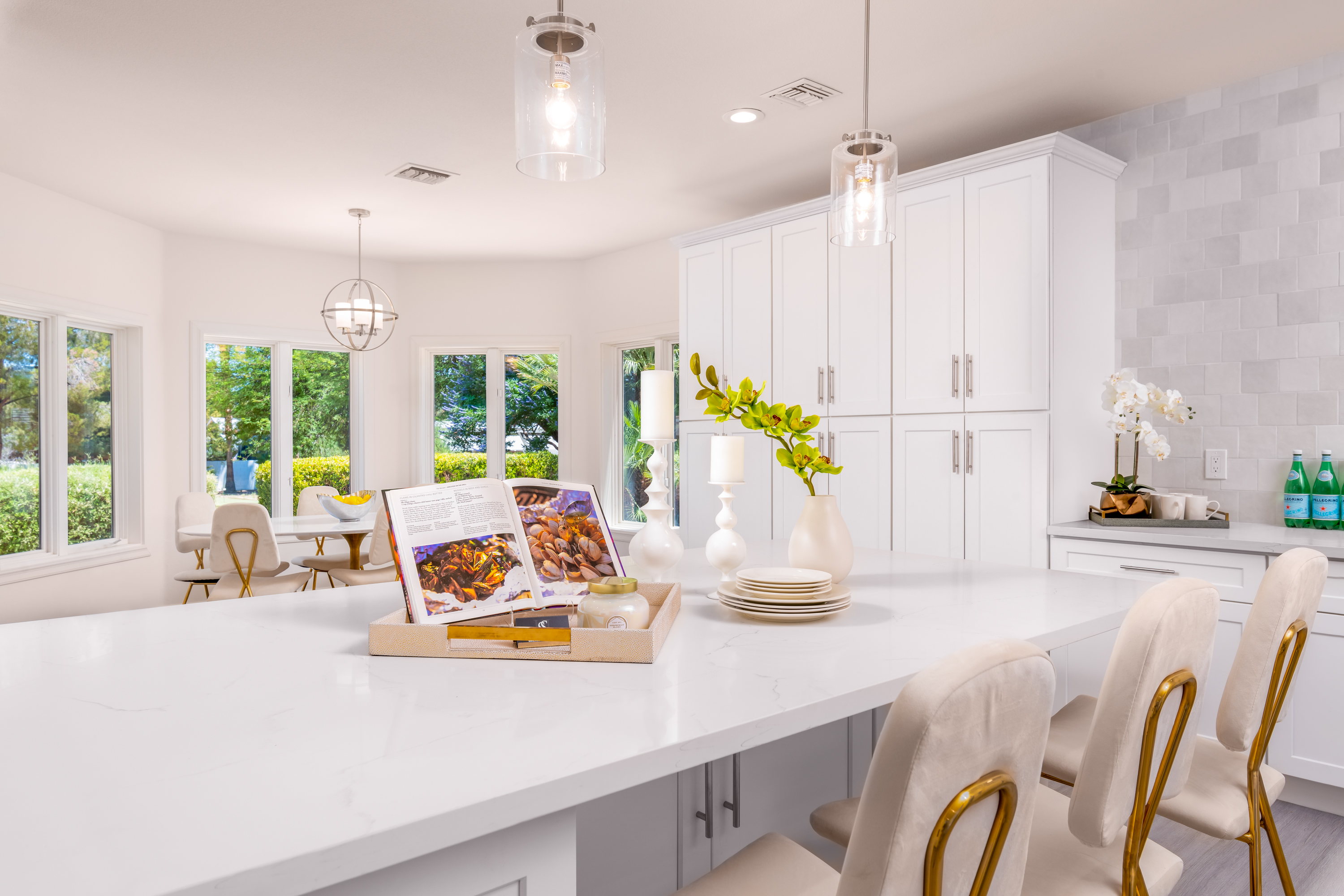 Kitchen at a Stately modern luxury fireplace centerpiece home in Las Vegas (3540 ETL) — herringbone tile fireplace, reclaimed wood drum table, bouclé chairs, arched windo