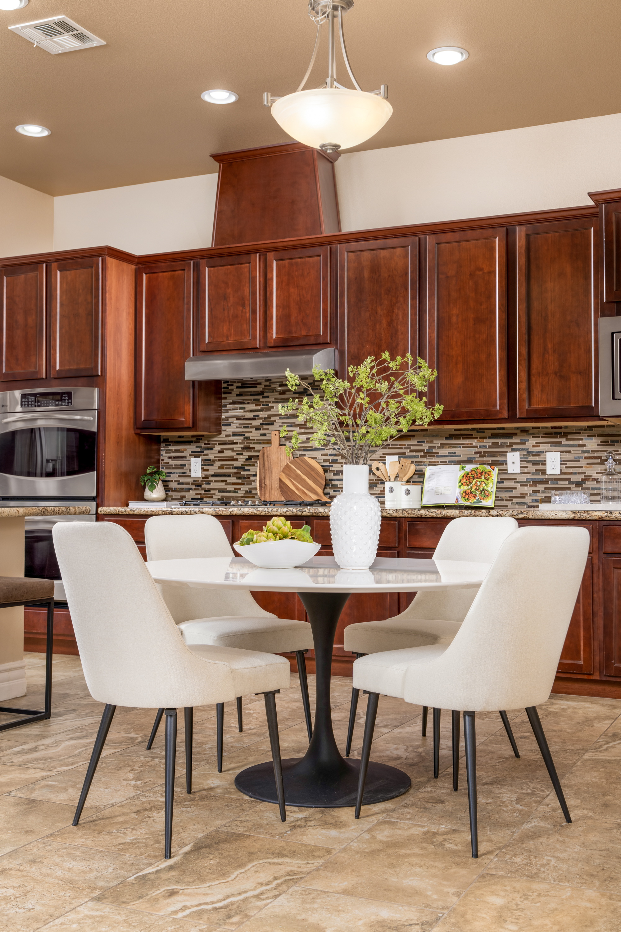 Breakfast Nook at a Stately desert ranch traditional home in Las Vegas (7714 FD) — wood-bladed windmill fan, tray ceiling, plantation shutters, swivel chairs.