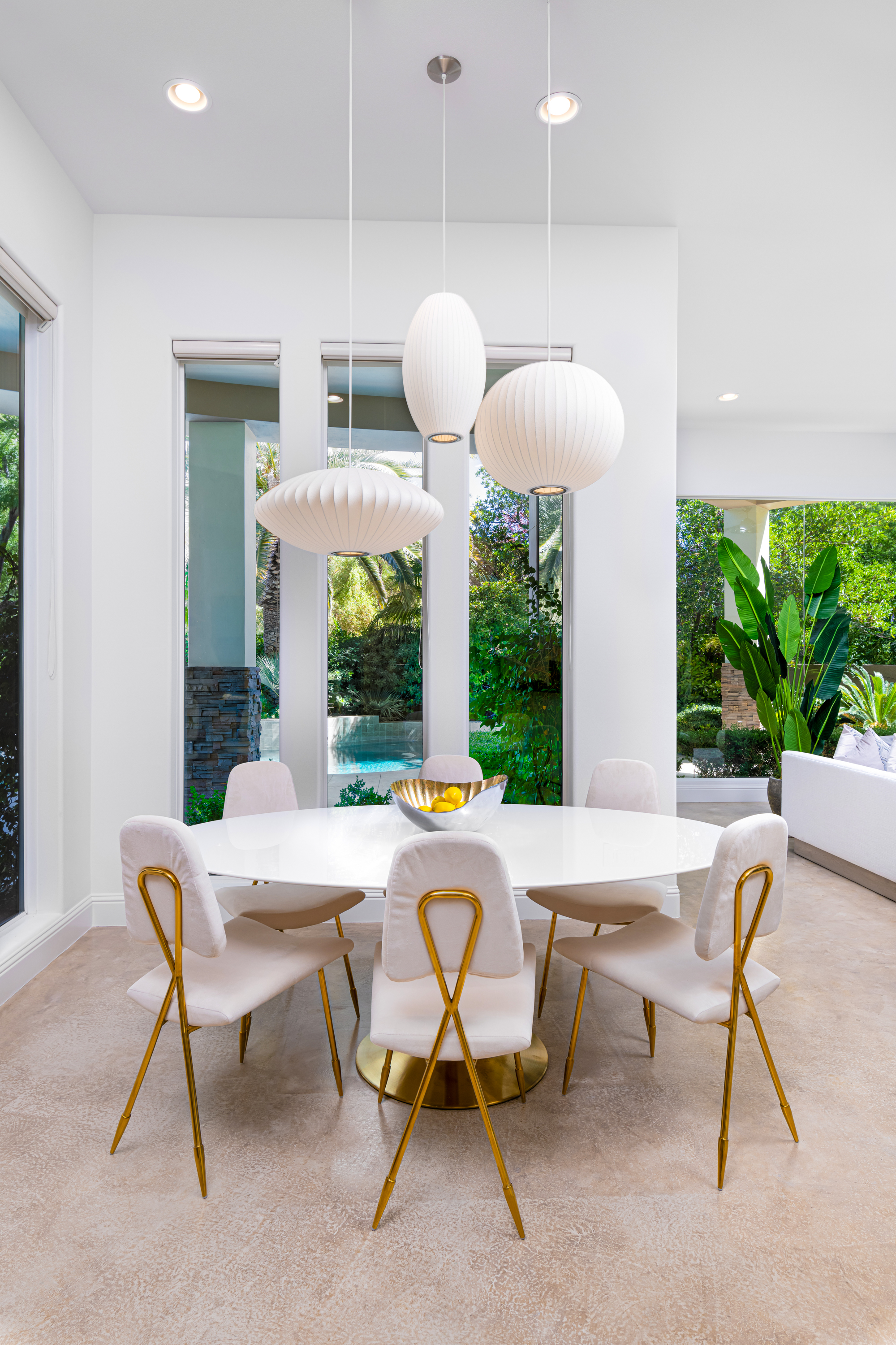 Breakfast Nook at a Stately modern luxury w/ wine display home in Las Vegas (9424 TCD) — cylindrical glass wine display, mid-century leather-and-brass chairs, sculptural
