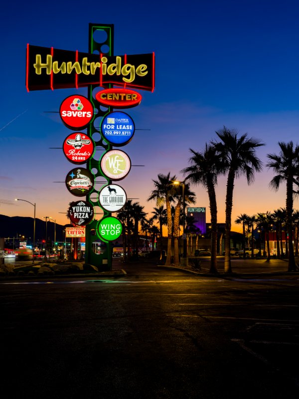 Huntridge Center pylon sign at dawn — Las Vegas mid-century neon: Savers, Roberto's, Capriotti's, Yukon Pizza, Huntridge Tavern, Wing Stop, Garrison, Dapper For Lease.