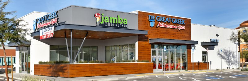 The Great Greek Mediterranean Grill grand-opening panoramic — multi-tenant Las Vegas storefront with Jamba Drive-Thru between Great Greek's two end signs, daylight sky.