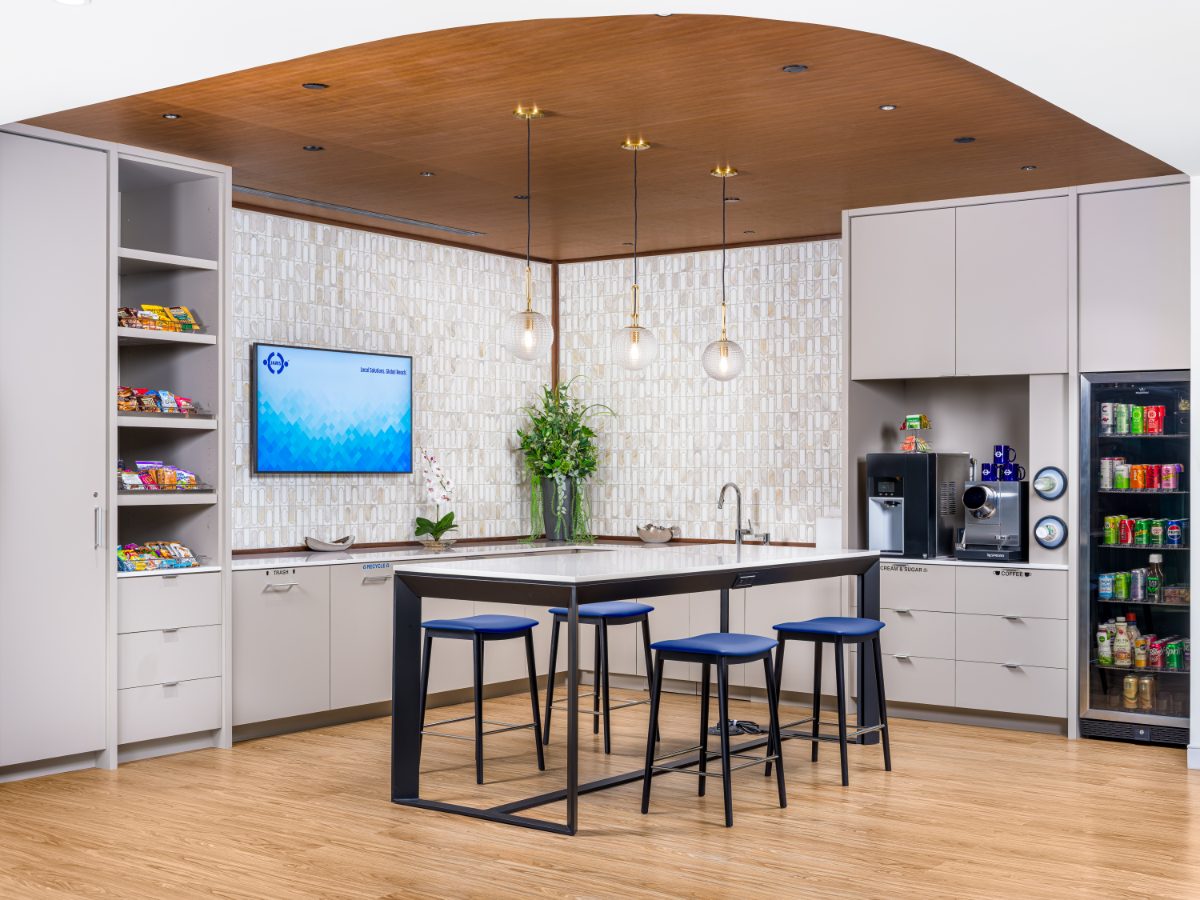 JAMS Cafe at the JAMS Washington, D.C. Resolution Center — island with four cobalt stools, three globe pendants, beverage fridge, snack shelf, curved wood ceiling.