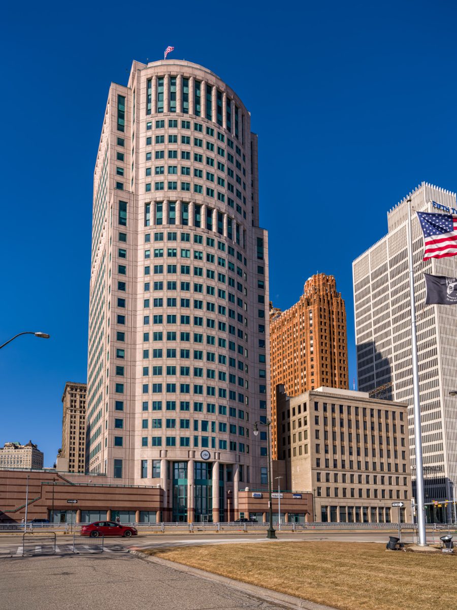150 West Jefferson — postmodern pink-limestone tower housing JAMS Detroit Resolution Center, with the colonnaded cylindrical crown above the orange Guardian Building.