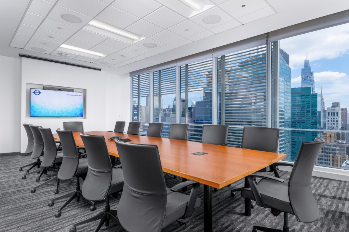 JAMS NY Conf Room 20 — long cherry table, black leather chairs, JAMS display, windows with NYT louvers framing the Chrysler Building and Midtown skyline.