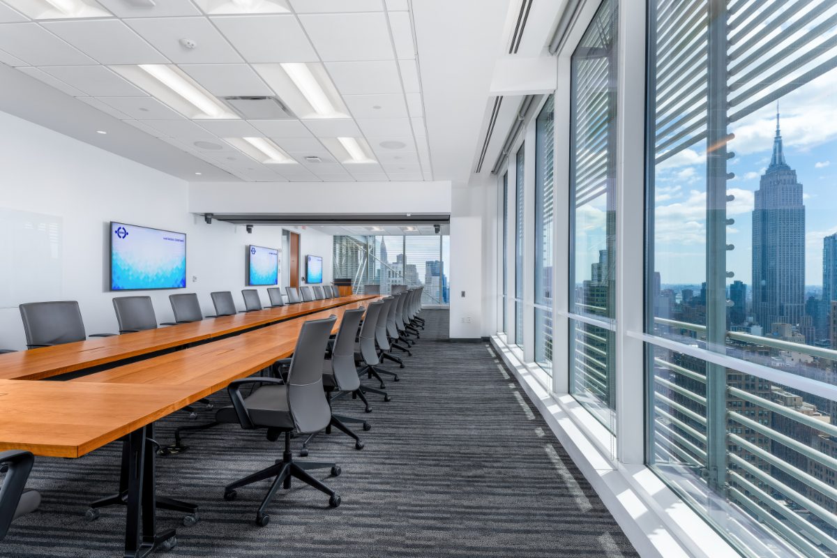 JAMS NY combined boardroom 26+28 — long cherry table leading the eye to floor-to-ceiling windows with NYT louvers, Empire State Building framed in the view.